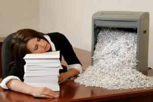 Woman exhausted after manually shredding paper
